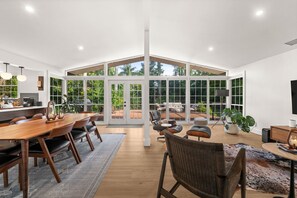 A spacious interior with a large dining area, seating arrangements, and a view through expansive windows.