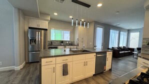A modern kitchen with a central island, stainless steel appliances, and pendant lighting. - Modern Remodeled Irvine Northwood Home (Irvine)