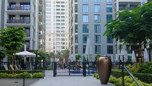 Een modern appartementencomplex met meerdere verdiepingen, balkons en een hekwerk.