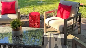 An outdoor patio area with a table, chairs, and a play structure in the background.