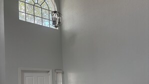 A spacious room with a large arched window, a white door, and a wall-mounted exercise machine. - All Inclusive Hotel- Montego Bay, Jamaica (Montego Bay)