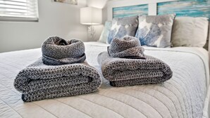 A neatly made bed with a quilted bedspread, a lamp, and a painting on the wall. - Tropical Oasis Heated Pool • Spa • Pool Table • Grill • Games • Beach 15 Minutes (Seminole)