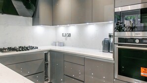 A modern kitchen with stainless steel appliances, a built-in oven, and a gas stove.