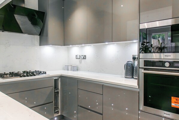 A modern kitchen with a built-in dishwasher, a gas stove, and a stainless steel oven.