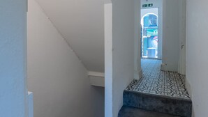 Una stretta scala con pavimento in piastrelle decorate che porta a una porta.