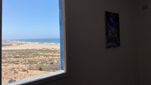 Una habitación con un amplio ventanal que da a la playa.