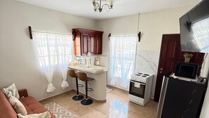 A compact living space with a kitchenette, a sofa, a dining area, and a TV. - Apartamento perfecto,  para viajes de trabajo o escapadas familiares. (San Pedro sula)
