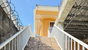 A staircase with stone steps and white railings leading to a building entrance. - Apartamento perfecto,  para viajes de trabajo o escapadas familiares. (San Pedro sula)