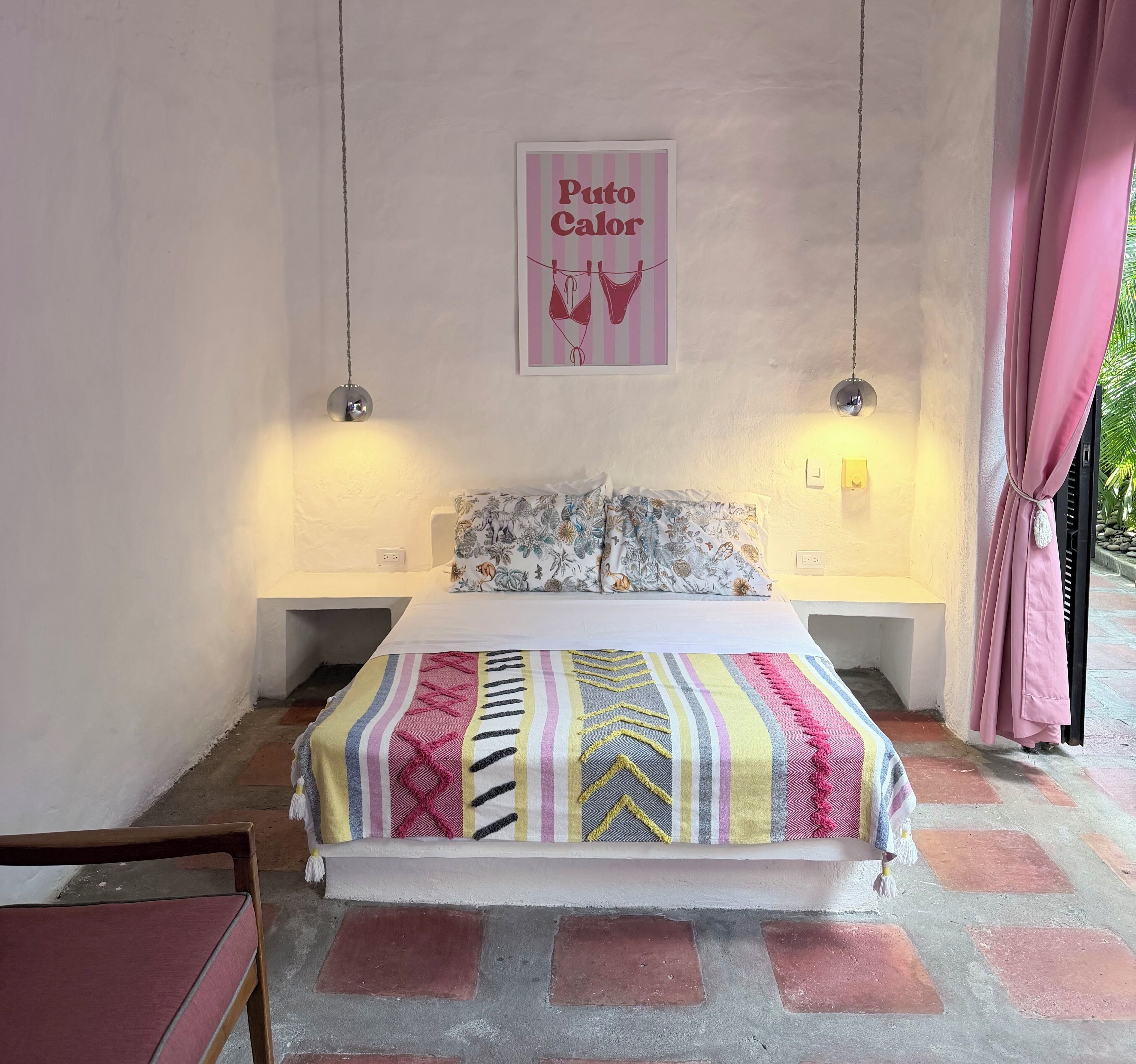 Ein Schlafzimmer mit einem Bett, einer Hängelampe, einer Wandleuchte und einem Bild.