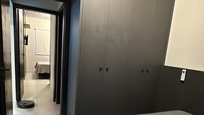 A hotel room with a large bed, a wardrobe, and a bathroom visible through an open door. - Your Sweet Home House in Içara near Criciúma!  A/C + bed with therapeutic massage+ (Içara)