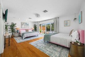 A bedroom with two beds, a large window, and a view of the outdoors. - Lakefront retreat - Heated Pool - 8 miles to Clearwater beach (Clearwater)