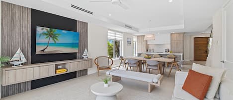 Una sala de estar moderna con un televisor de pantalla plana, un comedor y una cocina.