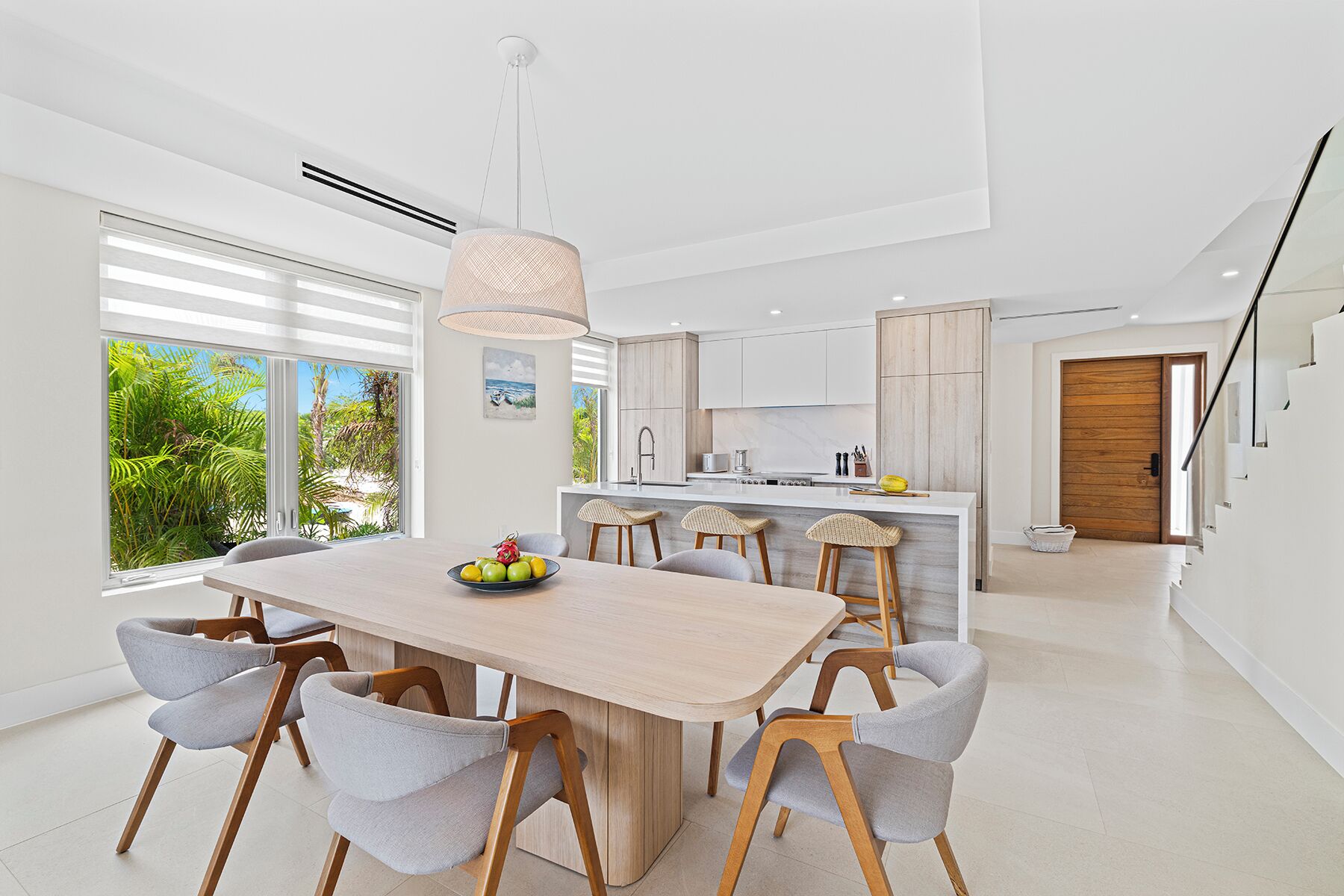 Cocina moderna con una isla central, ventanas amplias y vistas a zonas verdes.