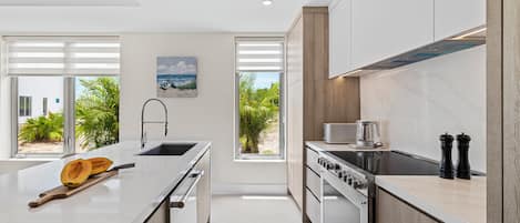 Una cocina moderna con una isla grande, horno empotrado y vistas al exterior.