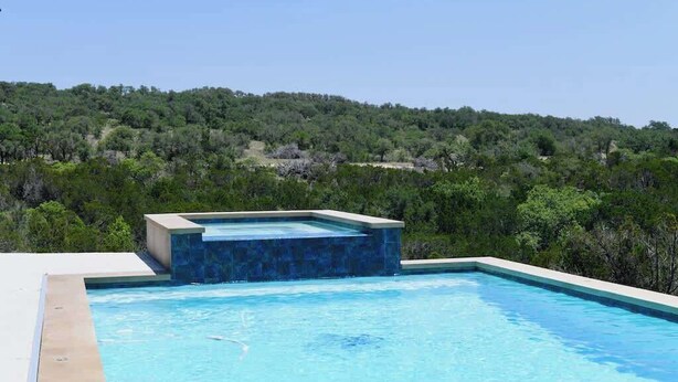 Una piscina con vistas a una ladera boscosa.