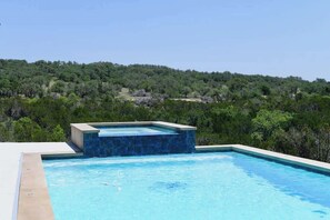 Una piscina con vistas a una ladera boscosa.