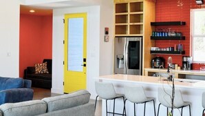 Una cocina moderna con una isla central, un refrigerador y un rebozo rojo.