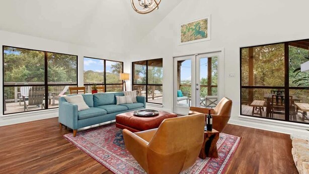 A spacious living room with a blue sofa, a brown leather chair, and a wooden coffee table.