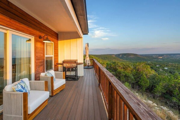Eine Holzterrasse mit Sitzgelegenheiten und Blick auf die Landschaft.