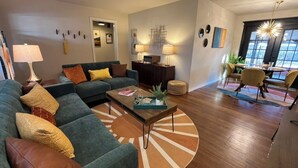 Ein modernes Wohnzimmer mit Sofa, Couchtisch und Essbereich.