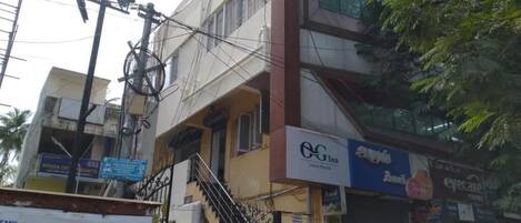A multi-story building with a staircase leading to the entrance. There are signs for a study challenge and a luxury room.