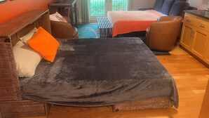 A hotel room with a bed, two chairs, a small table, and a cabinet. - Delightful 1-bedroom condo in Clemson. (Clemson)
