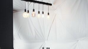A tented dining area with a round table, two chairs, and a hanging light fixture. - Golden Circle Domes - Lake View (Selfoss)