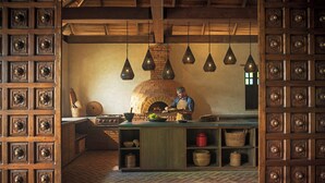 Una cucina rustica con un forno a mattoni, lampade a sospensione e mobili in legno.