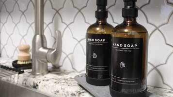 Dos botellas de detergente para platos y jabón de manos sobre una encimera de cocina.