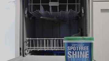 A dishwasher with a container of Dawn dish soap in front of it.