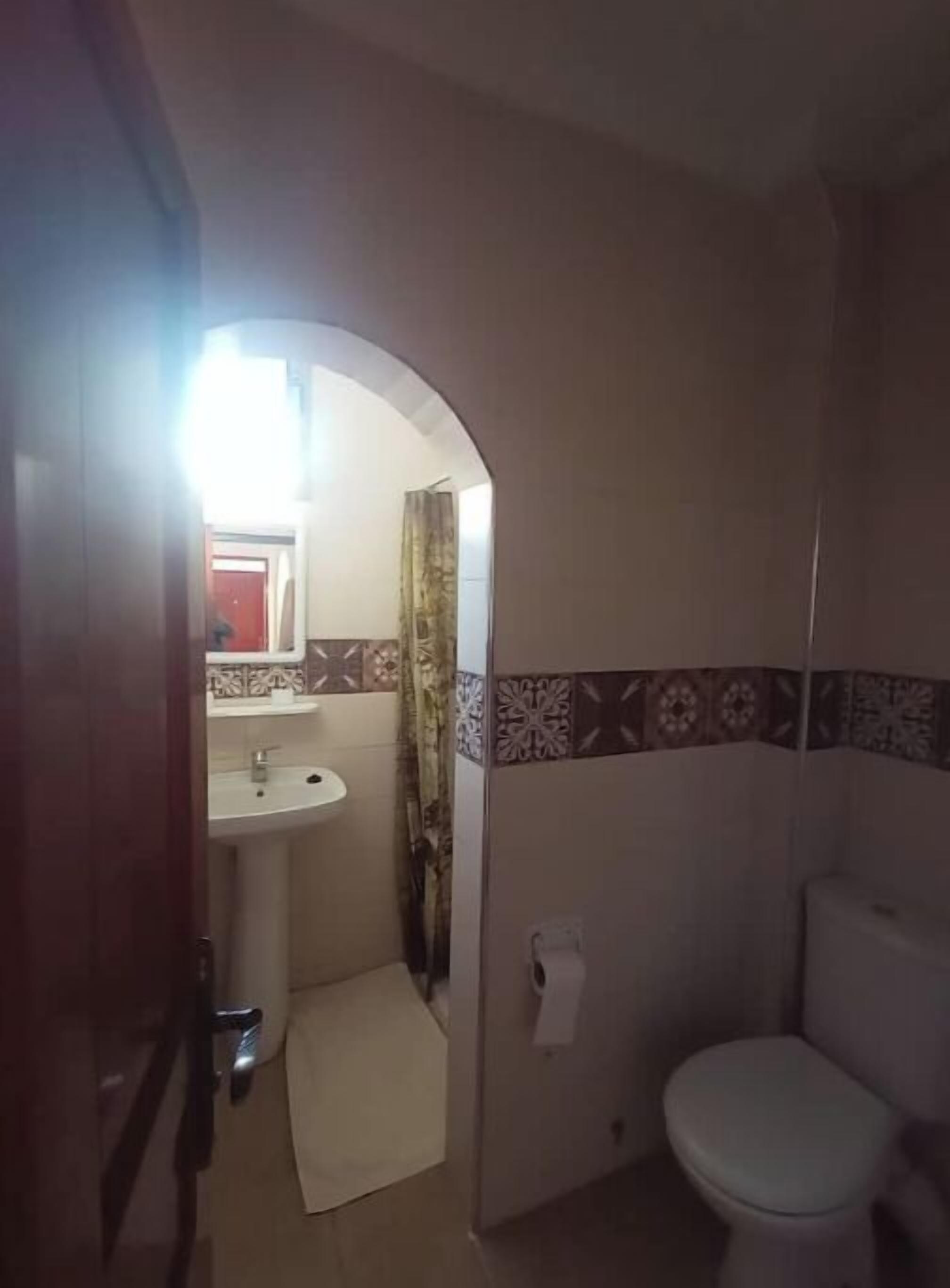 Une salle de bain avec un lavabo, des toilettes et un petit tapis.