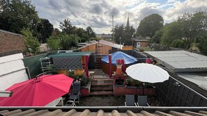 A residential area with a wooden structure, a red umbrella, and a white umbrella. - Cozy maisonette apartment with pool and sauna in Grevenbroich (Grevenbroich)