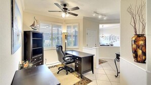 A home office with a desk, chair, and bookshelf.