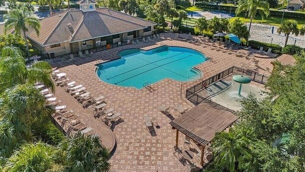 A swimming pool with lounge chairs and a wooden deck.
