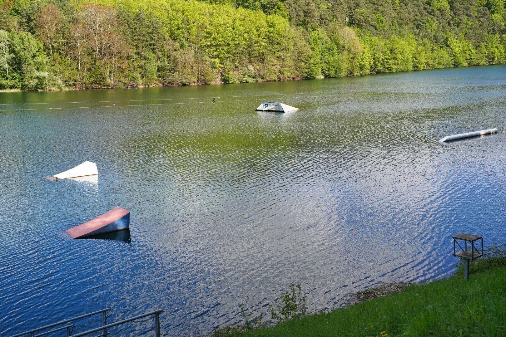 Ein ruhiger See mit Booten und einem Steg.
