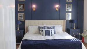 Una camera da letto con un letto grande, un comodino, una cassettiera e una panca.