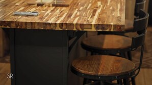 Zona pranzo con tavolo in legno, sedie e lampadario.