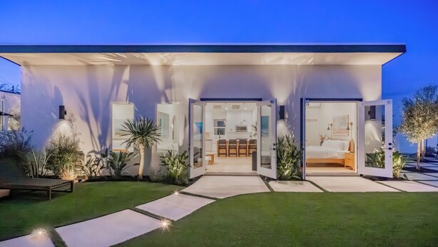 Una casa moderna con un espacio abierto que integra sala de estar, cocina y un dormitorio.
