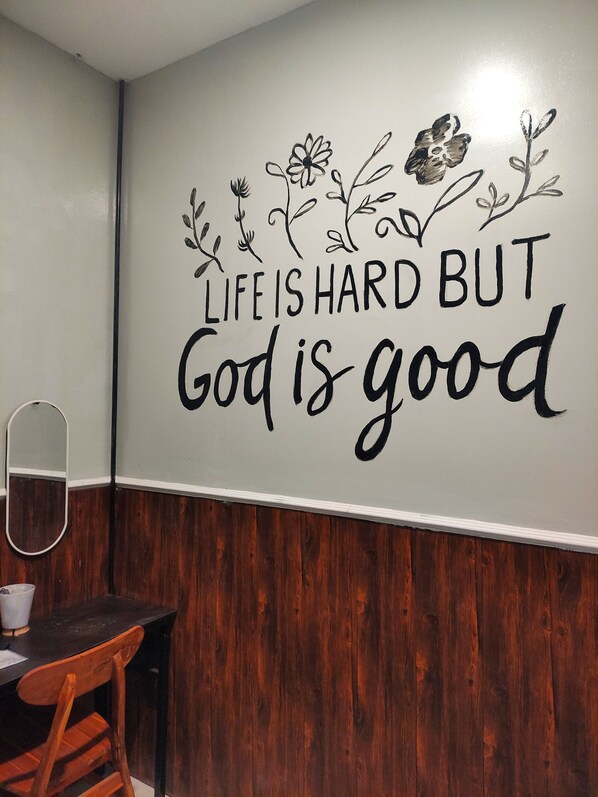 A wall with a motivational quote and decorative floral designs.