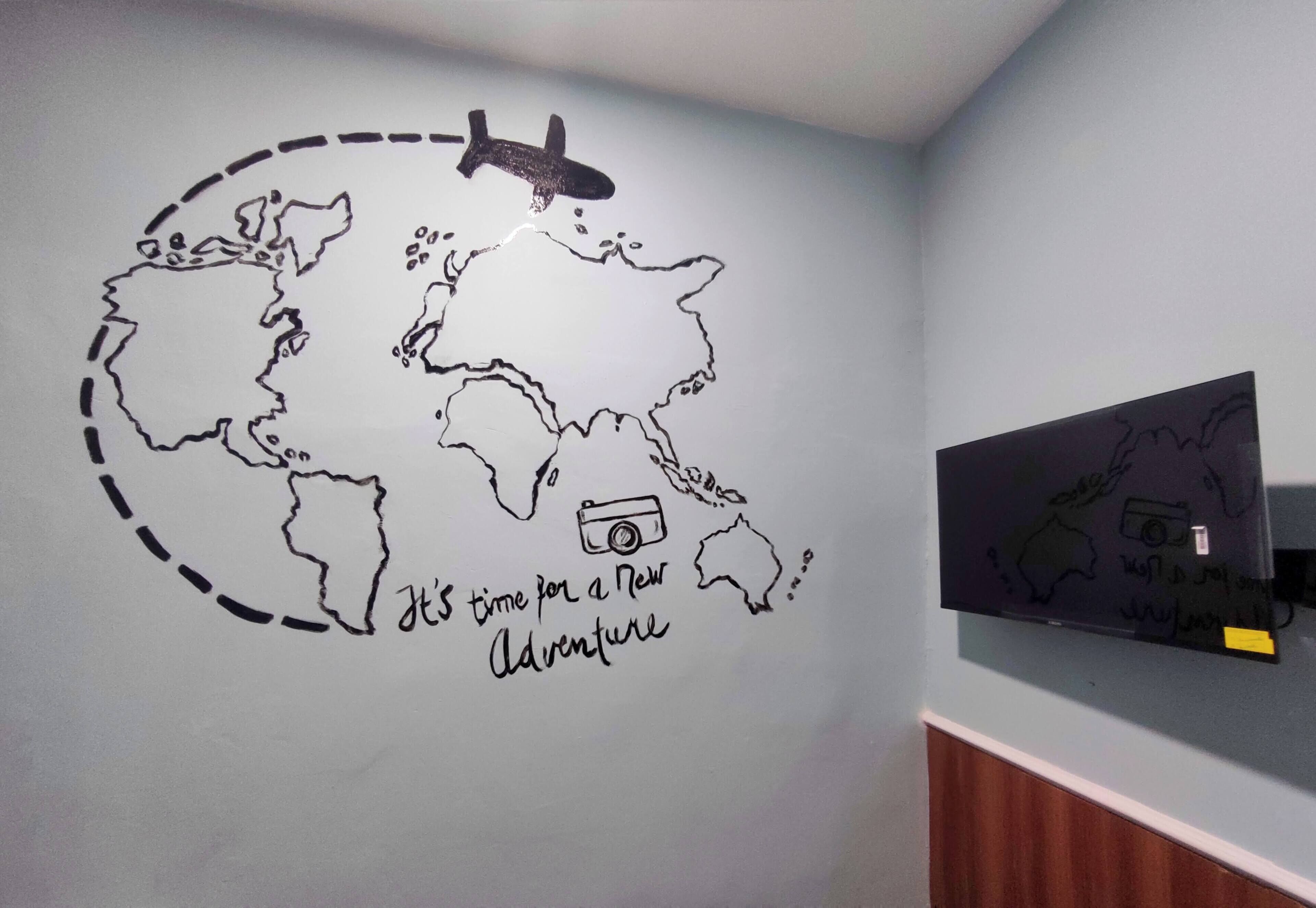 A wall with a world map and a camera icon, suggesting a theme of travel or photography.