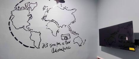 A wall with a world map and a camera icon, suggesting a theme of travel or photography.