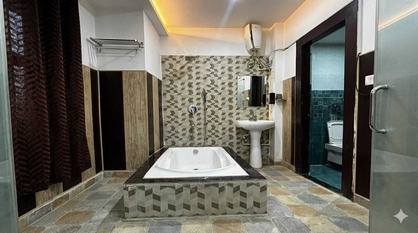 A modern bathroom with a large bathtub, a pedestal sink, and a shower area.