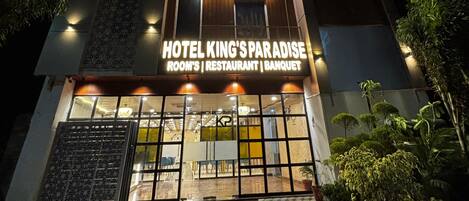 A multi-story building with a sign reading 'HOTEL KING'S PARADISE ROOM'S RESTAURANT BANQUET.'