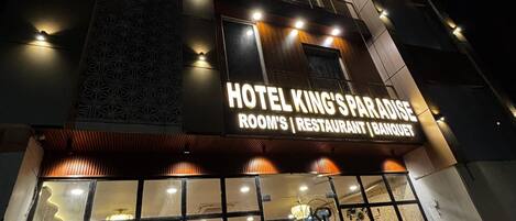 A hotel with a sign reading 'HOTEL KING'S PARADISE ROOM'S RESTAURANT BANQUET'.