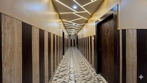 A hallway with patterned flooring, wooden paneling, and a door marked '207'. - Hotel Kings Paradise & Banquet (Lucknow)
