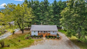 A two-story house with a porch, surrounded by dense forest. - Bee Happy Sparta Mountain Cottage (Sparta)