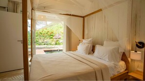 Une chambre à coucher avec un lit à baldaquin, une tête de lit en bois et une table de chevet avec une lampe.