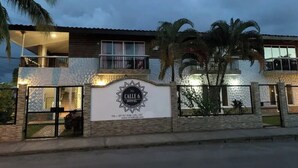 Un hotel amb un rètol ben visible, una entrada tancada amb reixeta i un balcó.