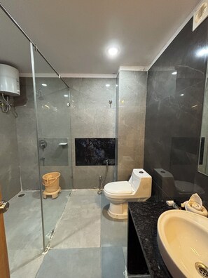 Un baño moderno con ducha envuelta en vidrio, inodoro y lavamanos.