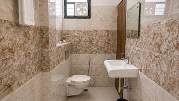 A modern bathroom with a toilet, sink, and shower.